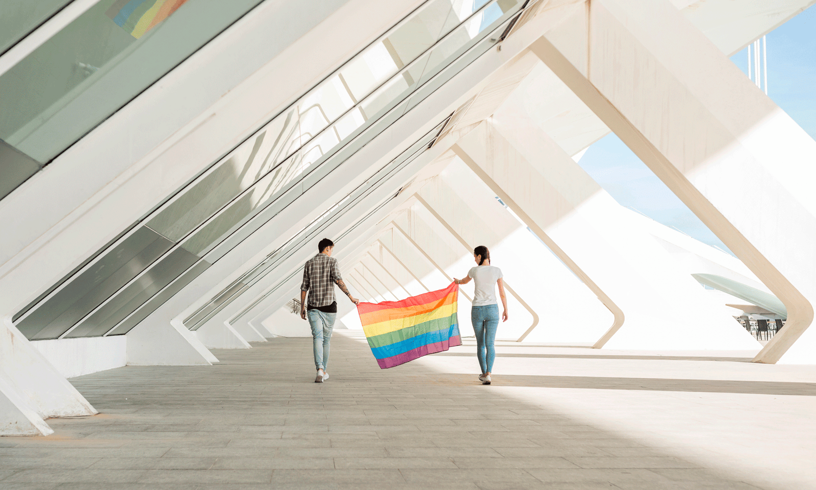 Una pareja sosteniendo una bandera de arcoíris